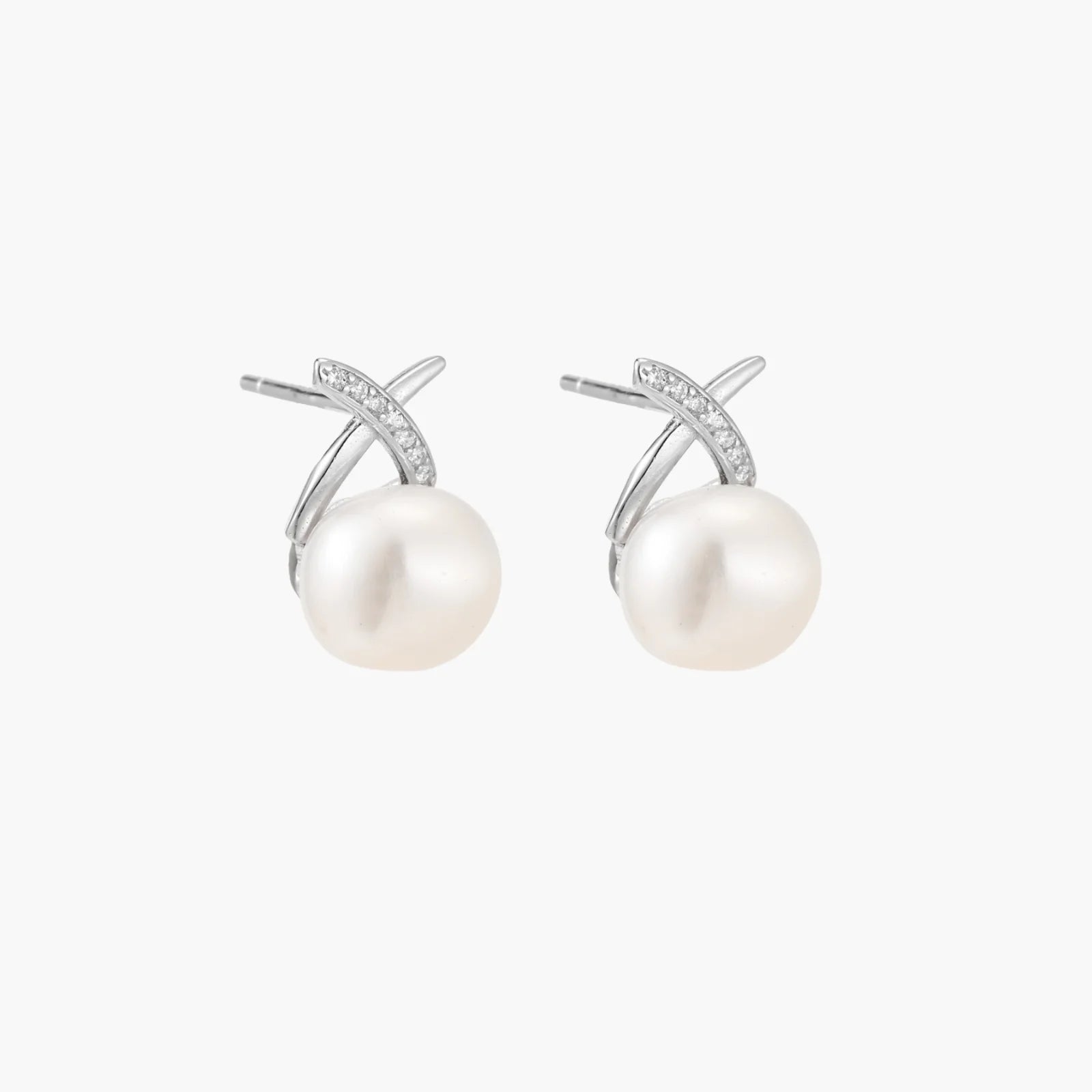 Rhodium-plated silver stud earrings with sparkling X design above lustrous round freshwater pearls on white background.