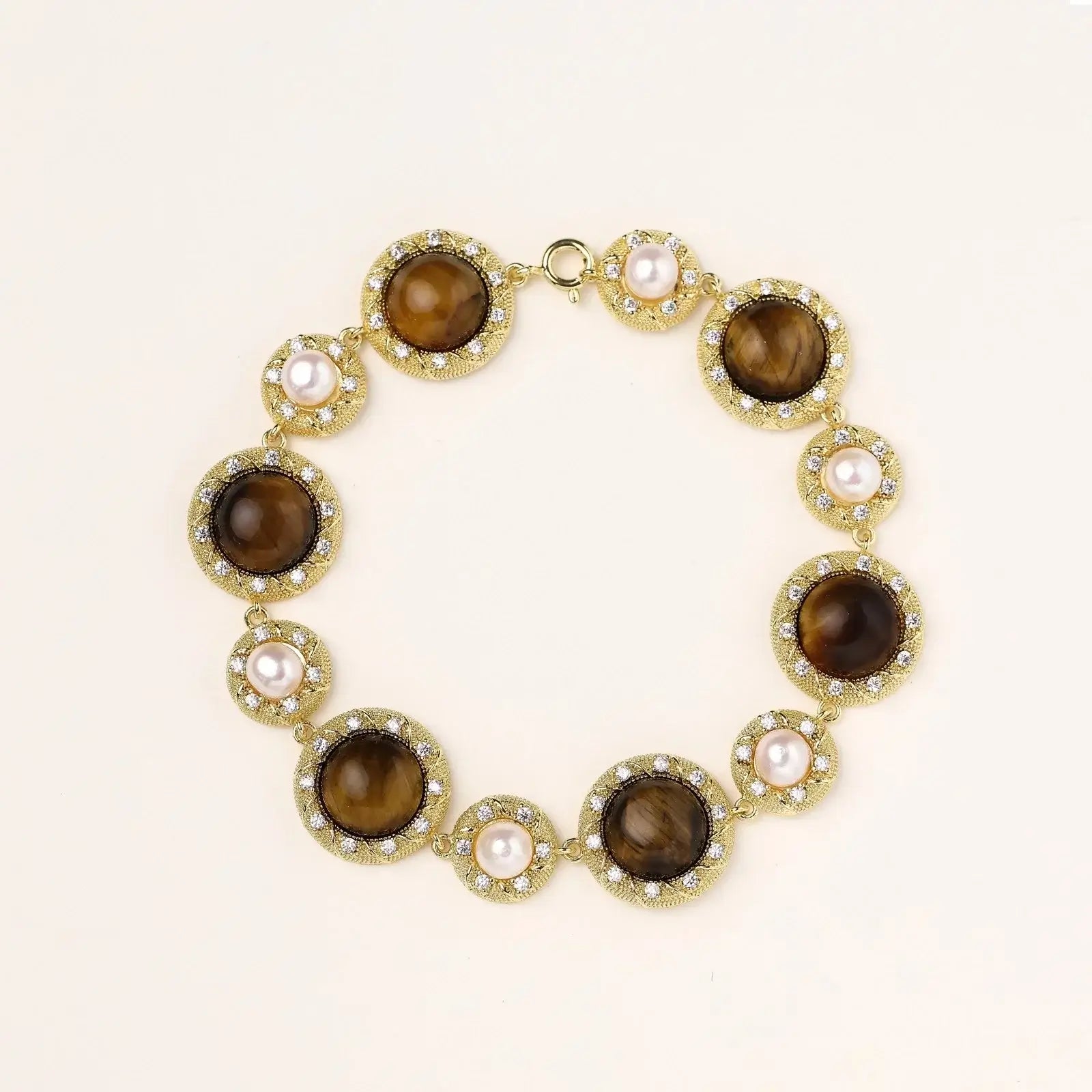 Gold-plated link bracelet with alternating brown tiger's eye stones and white freshwater pearls in ornate bezels.
